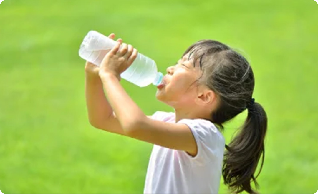 外で水分補給をする子ども
